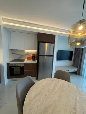 a kitchen with a refrigerator and a table with chairs at Super Luxury 1 bedroom apartment on 27th floor in Grand Sapphire in Phrenaros