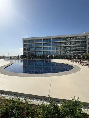 a building with a swimming pool in front of a building at Super Luxury 1 bedroom apartment on 27th floor in Grand Sapphire in Phrenaros