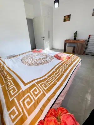 a bedroom with a bed with a blanket on it at Orange Sunset Duplex Lapta 2 bedrooms close to Merit Casino in Meniko