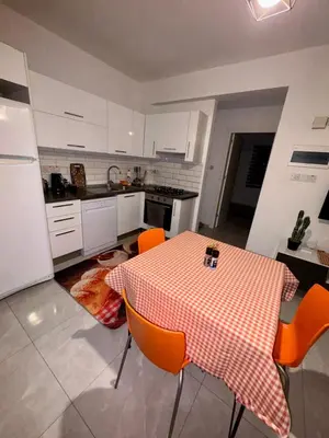 a kitchen with a table and orange chairs in it at Orange Sunset Duplex Lapta 2 bedrooms close to Merit Casino in Meniko