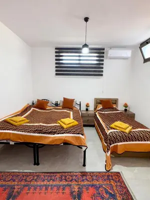 two beds in a room with a window at Orange Sunset Duplex Lapta 2 bedrooms close to Merit Casino in Meniko