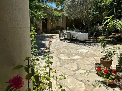 a patio with a table and chairs and flowers at Antonys Garden House in Episkopi Lemesou
