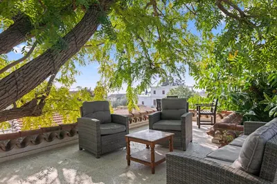 a patio with chairs and a table and trees at Antonys Garden House in Episkopi Lemesou