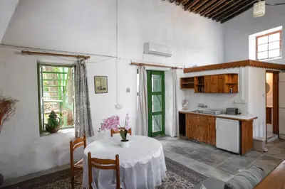 a kitchen and a table in a room with a table and a kitchen at Antonys Garden House in Episkopi Lemesou