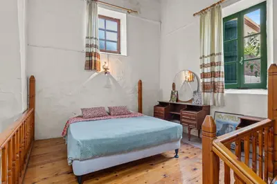 a bedroom with a bed and a desk and a window at Antonys Garden House in Episkopi Lemesou