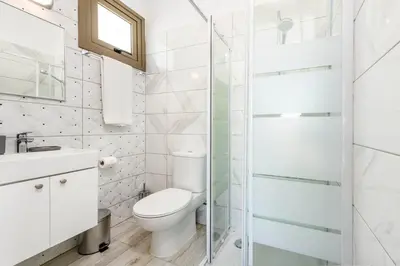 a white bathroom with a toilet and a shower at Villa Levanda #40 in Paralimni