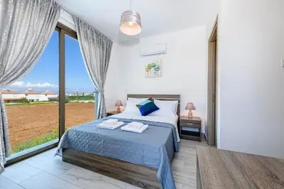 a bedroom with a bed and a large window at Villa Levanda #40 in Paralimni