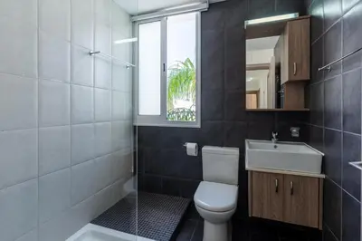 a bathroom with a toilet and a sink and a window at White Pearl Villa Protaras 7 in Paralimni