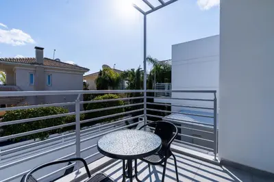 a patio with a table and chairs on a balcony at White Pearl Villa Protaras 7 in Paralimni
