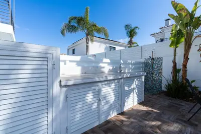 a white fence in front of a white house at White Pearl Villa Protaras 7 in Paralimni