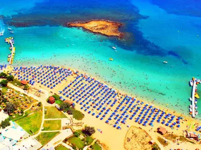 an aerial view of a beach with a group of umbrellas at Fig Tree Beach Villa Four in Protaras