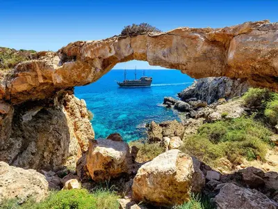 an archway with a boat in the water at Fig Tree Beach Villa Five in Protaras