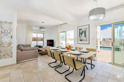 a living room with a table and chairs and a couch at Fig Tree Beach Villa Five in Protaras