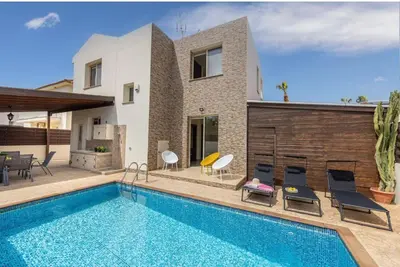 a villa with a swimming pool in front of a house at Daffodil villa in Pernera in Protaras