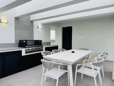 a kitchen with a white table and chairs at Makenzie View Penthouse in Larnaka