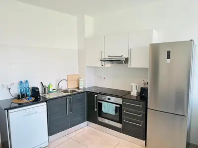 a kitchen with black and white appliances and a refrigerator at Beachfront Seaview Apartment in Paralimni