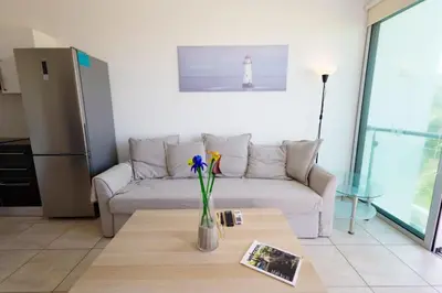 a living room with a couch and a table at Beachfront Seaview Apartment in Paralimni