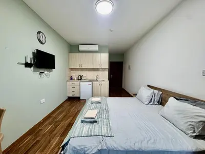 a bedroom with a large bed and a kitchen at Room in EkinAdademir Dorm North Cyprus in Nicosia