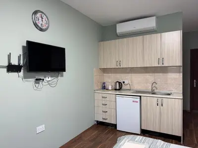 a kitchen with a refrigerator and a tv on the wall at Room in EkinAdademir Dorm North Cyprus in Nicosia