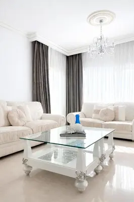 a white living room with a white couch and a glass table at Gulf Beach Apartment by TrulyCyprus in Limassol