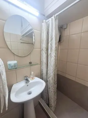 a bathroom with a sink and a mirror and a shower at Olive studio in Limassol