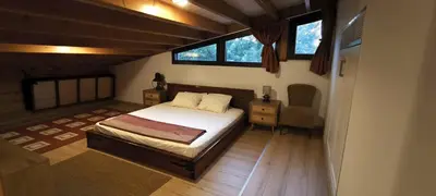 a bedroom with a bed and a desk and two windows at The Zephyr House -2- in Pyrgos