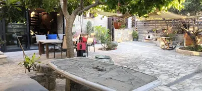 a stone patio with a table and a tree at The Zephyr House -2- in Pyrgos