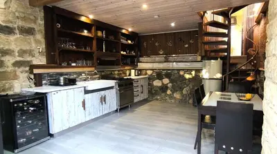 a large kitchen with wooden cabinets and a stove at The Zephyr House -2- in Pyrgos