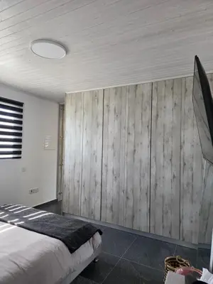 a bedroom with a bed and a wooden wall at Relaxing small home