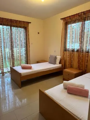 a bedroom with two beds and two windows at Натали апарт in Paralimni