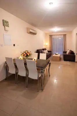 a living room with a table and chairs and a couch at Натали апарт in Paralimni