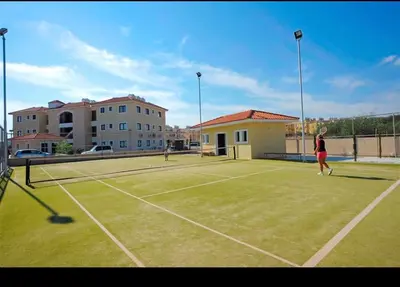 two people playing tennis on a tennis court at Натали апарт in Paralimni