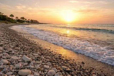a beach with rocks and the ocean at sunset at Modern Seaside Apartment Steps to the Beach in Pervolia