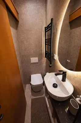 a bathroom with a sink and a toilet and a mirror at Modern Seaside Apartment Steps to the Beach in Pervolia