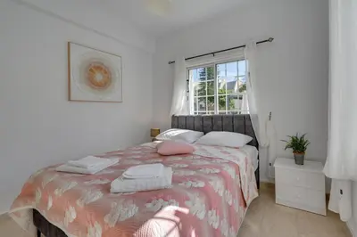 a bedroom with a bed with two pillows and a window at Oceanic Pearl Villa Deluxe - 200m from beach in Voroklini