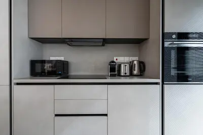 a kitchen with white cabinets and a microwave at Aoki 3-Bedroom Luxury Apartment in Limassol