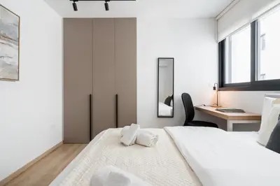 a white bedroom with a large bed and a desk at Aoki 3-Bedroom Luxury Apartment in Limassol