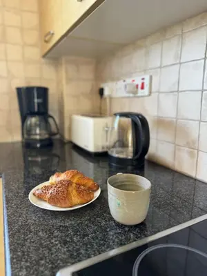 a pastry on a plate on a counter in a kitchen at NISSI ELENA Family Apt FREE WIFI in Ayia Napa