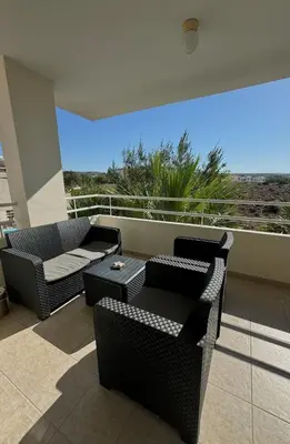 a balcony with two chairs and a couch and a table at NISSI ELENA Family Apt FREE WIFI in Ayia Napa