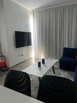 a living room with a table and a blue couch at Sea view Appartment in Larnaka
