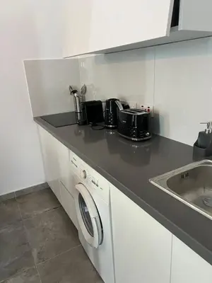 a kitchen with a washing machine and a sink at Sea view Appartment in Larnaka