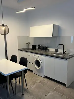 a kitchen with a washing machine and a table at Sea view Appartment in Larnaka