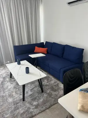 a living room with a blue couch and two tables at Sea view Appartment in Larnaka