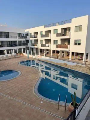 a swimming pool in front of a apartment building at Fiori Apartments in Paralimni