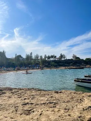 a boat in the water next to a beach at Fiori Apartments in Paralimni