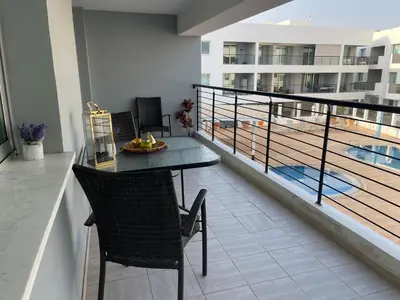 a balcony with a table and chairs and a pool at Fiori Apartments in Paralimni