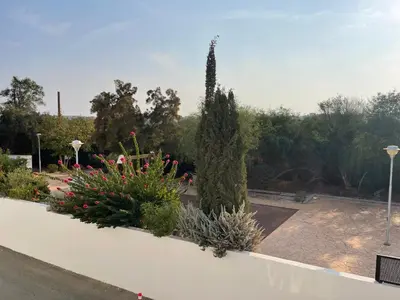 a garden with flowers and plants on a white wall at Fiori Apartments in Paralimni