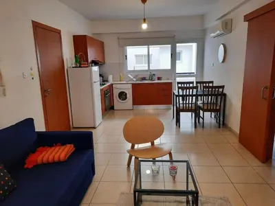 a living room with a blue couch and a kitchen at City Center Walking to the Beach 2 Bedrooms in Larnaka