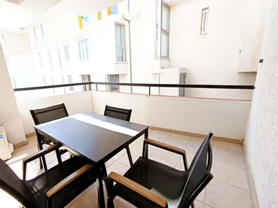 a table and chairs in a room with a balcony at City Center Walking to the Beach 2 Bedrooms in Larnaka