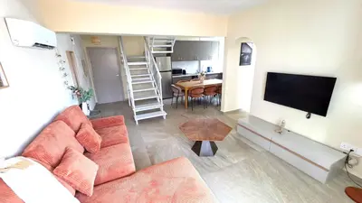 a living room with a couch and a flat screen tv at Warm Design 3BR, Beach 7-min walk, Peaceful in Larnaka